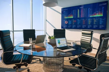 Ambiente de escritório com mesa de conferência de vidro, cadeiras ergonômicas e tela exibindo visualizações de dados coloridas.